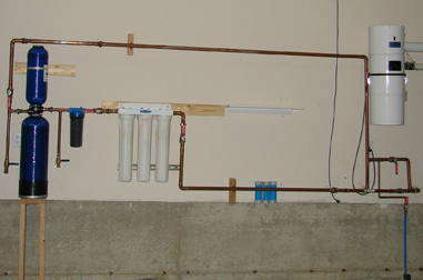 Plumbing and filtration ahead of WoLF Installation on garage wall.